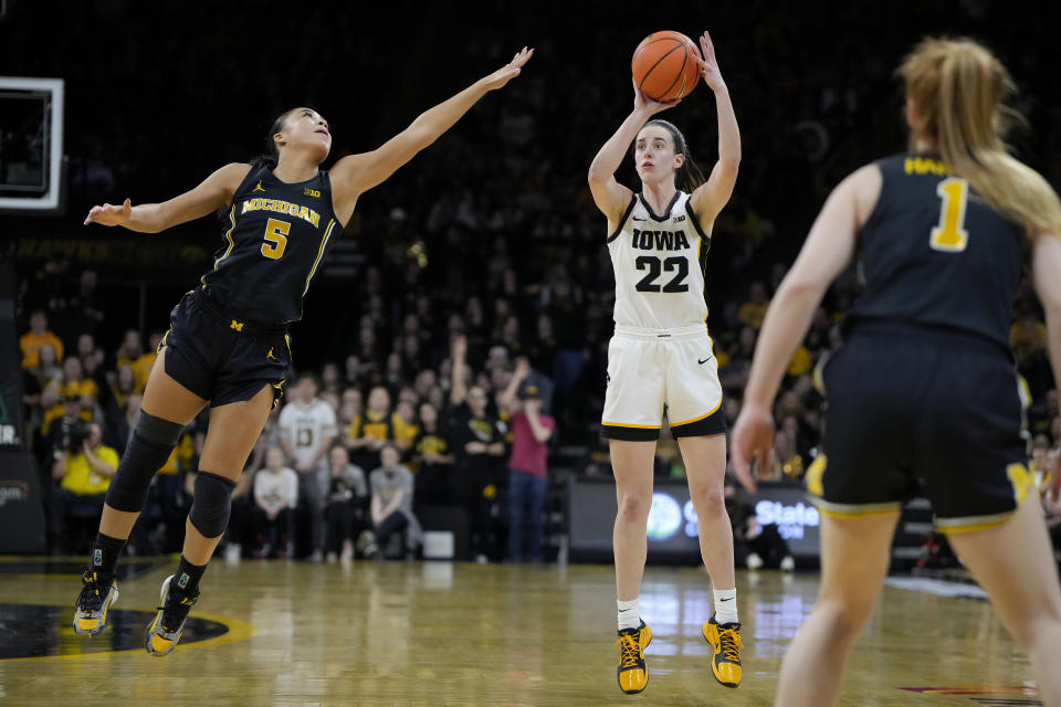 Iowa guard Caitlin Clark (22) shoots a 3-pointer as Michigan guard Laila Phelia (5) is late to defend during the second half of an NCAA college basketball game, Thursday, Feb. 15, 2024, in Iowa City, Iowa. (AP Photo/Matthew Putney)