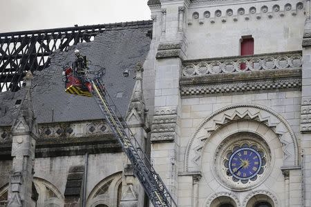 French firefighters try to extinguish the fire that damaged the roof of the Saint Donatien Basilica in Nantes, western France, June 15, 2015. REUTERS/Stephane Mahe