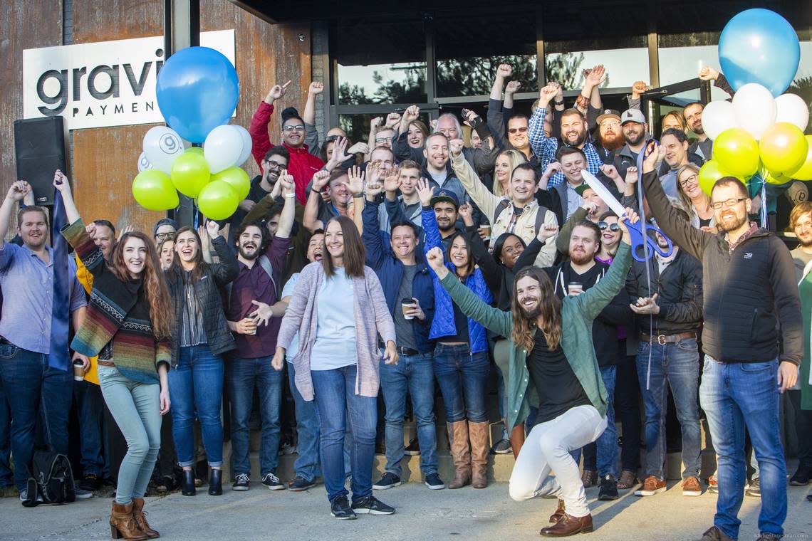 Dan Price, center right in green shirt, CEO of Gravity Payments, and Tammi Kroll, center left in pale blue, celebrate the opening of Gravity Payments’ new Boise office - as well as Price’s announcement that all employees, who are currently earning a minimum of $40,000, will be given an immediate raise to $50,000 and will be phased to $70,000 over the next four years.