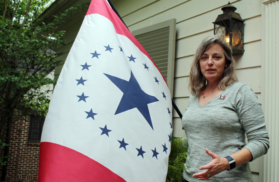 Laurin Stennis, an artist, speaks outside her home in Jackson, Miss., on Wednesday, April 17, 2019, and explains how she thinks a flag she designed, which flies next to her, would be an appropriate symbol to replace the state flag that Mississippi has used since 1894. The current flag includes the Confederate battle emblem, and Stennis's design does not. Mississippi Gov. Phil Bryant has signed a bill that authorizes several new specialty license plates, including one featuring the "Stennis flag." (AP Photo/Emily Wagster Pettus)