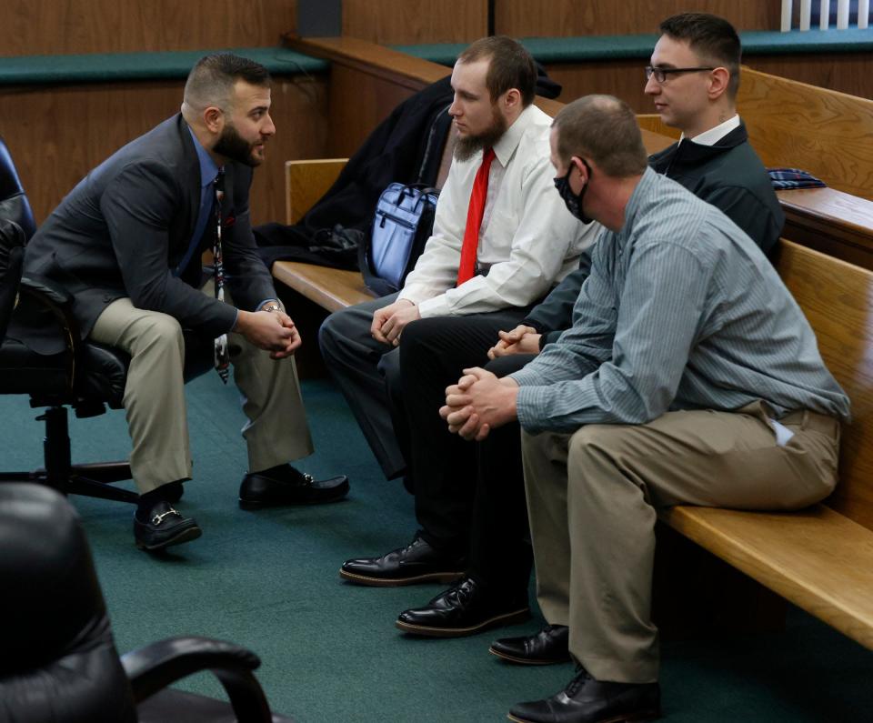 (L to R) Nicholas Somberg, attorney for Joseph Morrison, talks to his client as Paul Bellar and Pete Musico listen in the courtroom of Judge Thomas Wilson at the Jackson County Circuit Court in Jackson on Feb. 23, 2022. All three were in court during a hearing about the Gov. Gretchen Whitmer kidnapping plot they were allegedly involved in.