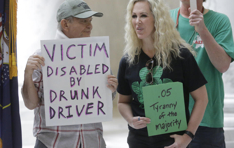 FILE — In this March 17, 2017, file photo, Ed Staley, left, and Tali Bruce, right, attend a rally concerning the DUI threshold at the Utah state Capitol in Salt Lake City. Car crashes and traffic deaths decreased in Utah the after state enacted the strictest drunken driving laws in the nation. A study published, Friday, Feb. 11, 2022, by the National Highway Traffic Safety Administration suggests Utah's roads became safer after the state lower the drunken driving threshold to .05% blood-alcohol content. (AP Photo/Rick Bowmer, File)