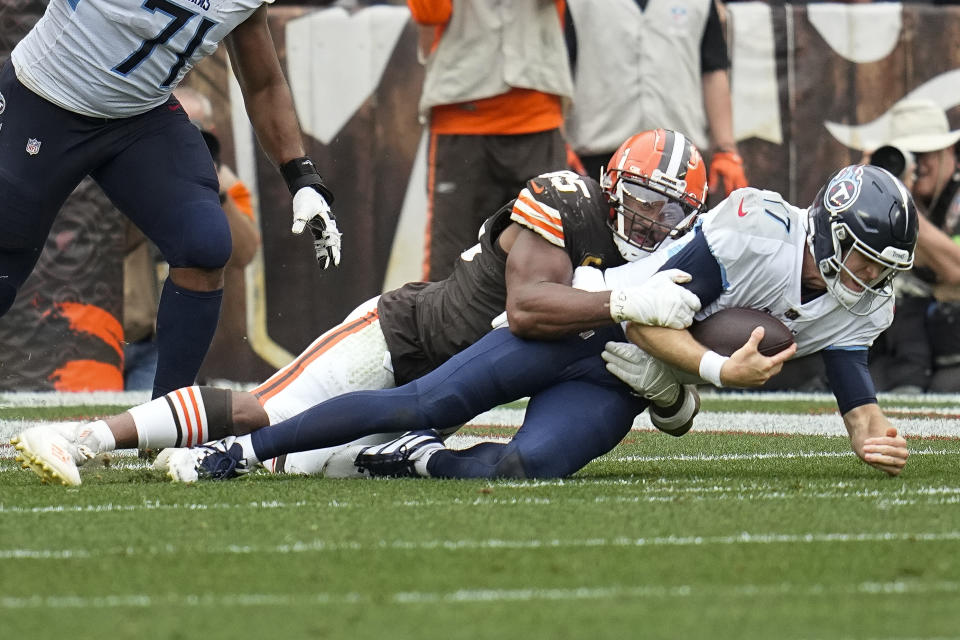 Cleveland Browns defensive end Myles Garrett, left, sacks Tennessee Titans quarterback Ryan Tannehill, right, during the second half of an NFL football game Sunday, Sept. 24, 2023, in Cleveland. (AP Photo/Sue Ogrocki)