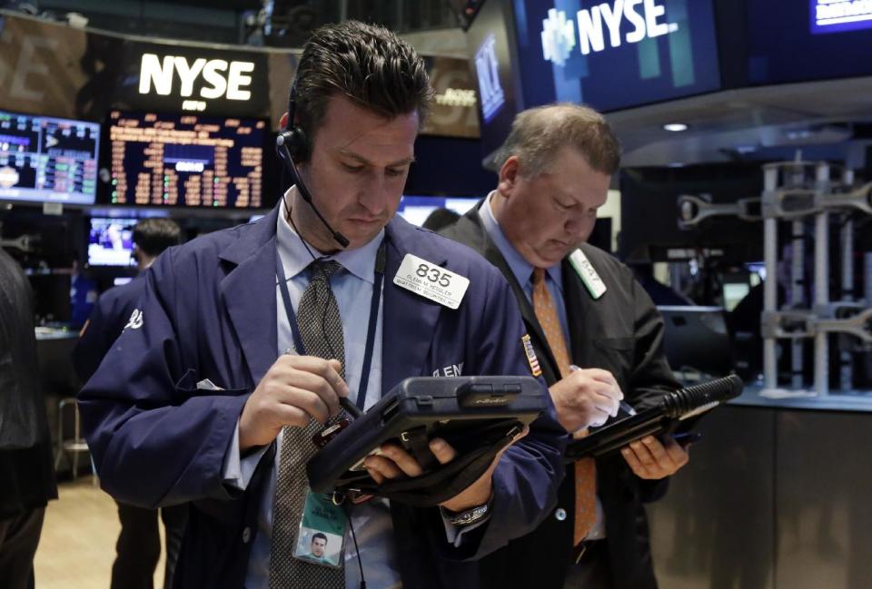 Traders Glenn Kessler, left, and George Ettinger work on the floor of the New York Stock Exchange, Tuesday, April 22, 2014. Stock futures edged higher as more companies reported first quarter earnings. (AP Photo/Richard Drew)