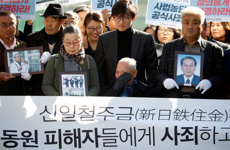 Lee Choon-shik, a victim of wartime forced labor during the Japanese colonial period, reacts as he arrives with supporters holding portraits of fellow deceased laborers in Seoul, South Korea, October 30, 2018. REUTERS/Kim Hong-Ji