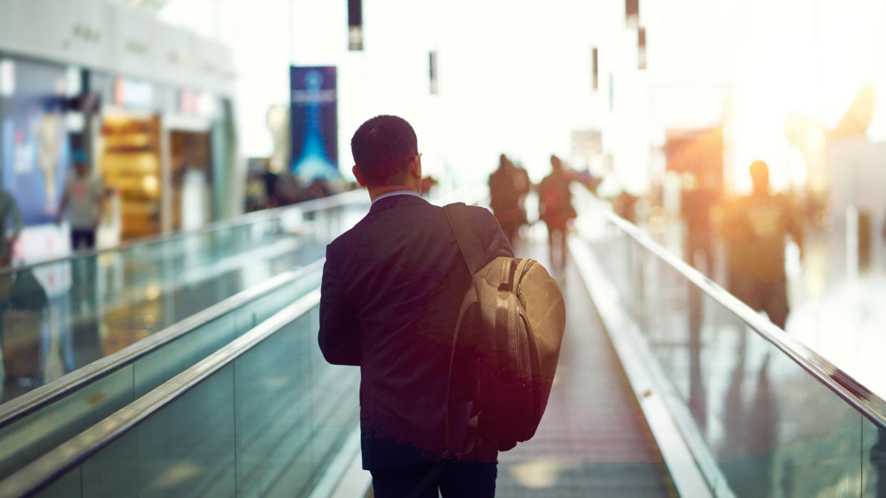 rear view of Asian businessman walking in departure area of  Shenzhen airport, China.