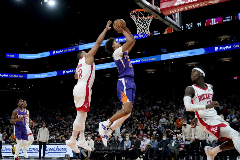 Phoenix Suns forward Cameron Johnson (23) shoots as Houston Rockets guard Eric Gordon (10) defends during the second half of an NBA basketball game Wednesday, Feb. 16, 2022, in Phoenix. The Suns won 124-121. (AP Photo/Matt York)