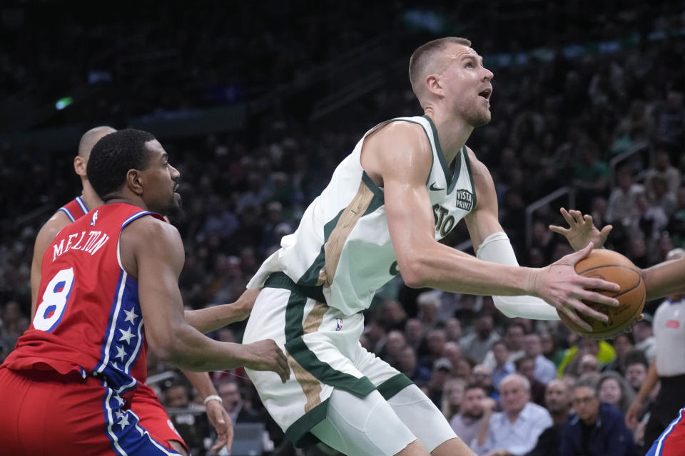 Boston Celtics center Kristaps Porzingis, right, drives past Philadelphia 76ers guard De'Anthony Melton (8) during the first half of an NBA basketball game, Tuesday, Feb. 27, 2024, in Boston. (AP Photo/Charles Krupa)