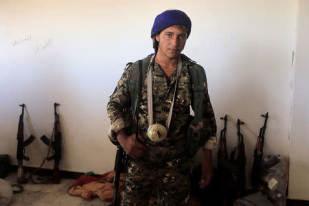 Kahran, 17, a member of the Syrian Democratic Forces is pictured with his homemade grenade during fighting with Islamic state in Al Senaa, a district of Raqqa. REUTERS/Zohra Bensemra