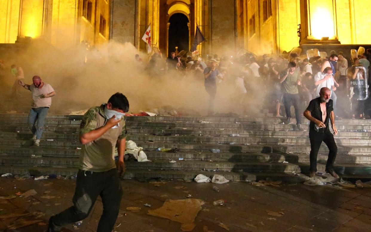 Demonstrators run from police tear gas after a Russian MP's appearance in the Georgian parliament sparked unrest - AP