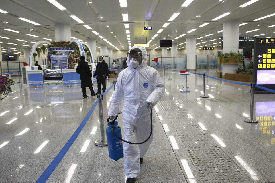 FILE - In this Feb. 1, 2020, file photo, a staff member of State Commission of Quality Management in protective gear carries a disinfectant spray can as they continue to check the health of travelers in foreign countries and inspect and quarantine goods being delivered via the borders at the Pyongyang Airport in Pyongyang, North Korea. A U.N. spokesman said the world body has been left with no international staff in North Korea and its North Korean employees are working remotely. Despite claiming to be coronavirus free, North Korea has sealed off its borders as part of stringent anti-pandemic measures that also involved the departure of diplomats and foreign nationals. (AP Photo/Jon Chol Jin, File)