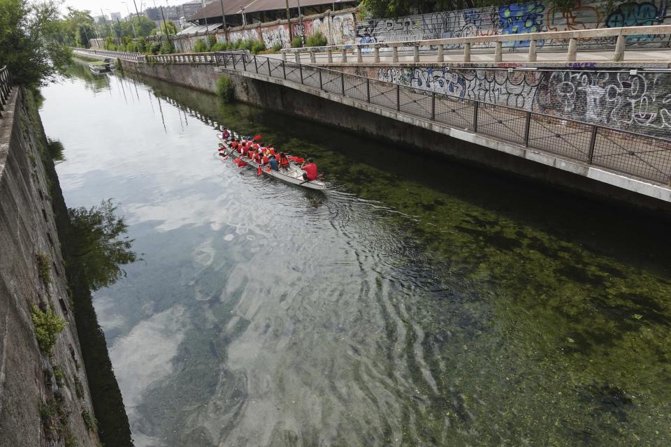 Un bote recorre una canal de Milán cuyas aguas están bajísimas, al punto de que se puede ver el fondo, por la falta de lluvias el 23 de junio del 2022. (AP Photo/Luca Bruno)