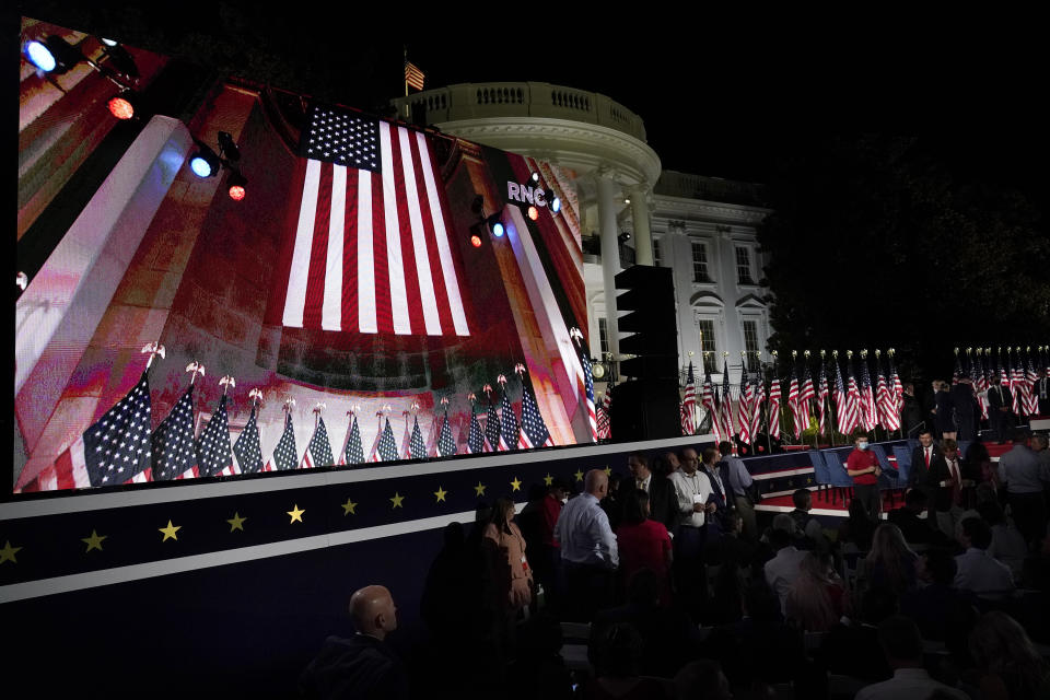 The Republican National Convention video is displayed on a screen as people watch from the South Lawn of the White House on the fourth day of the convention Thursday, Aug. 27, 2020, in Washington. (AP Photo/Alex Brandon)