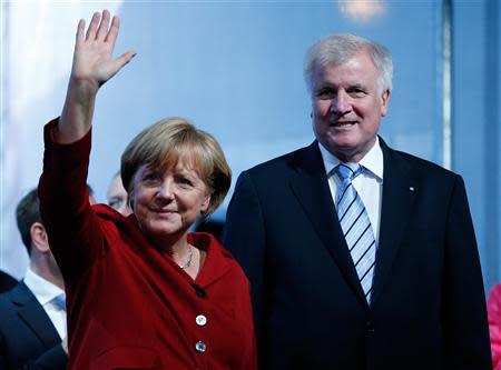 German Chancellor Angela Merkel and Bavarian state Premier Horst Seehofer wave after a Christian Democratic Union election campaign meeting in Augsburg September 19, 2013. REUTERS/Michael Dalder