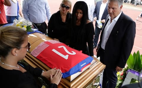 Family members place Amilcar Henriquez's national team jersey over his coffin after he was gunned down - Credit: Arnulfo Franco/AP