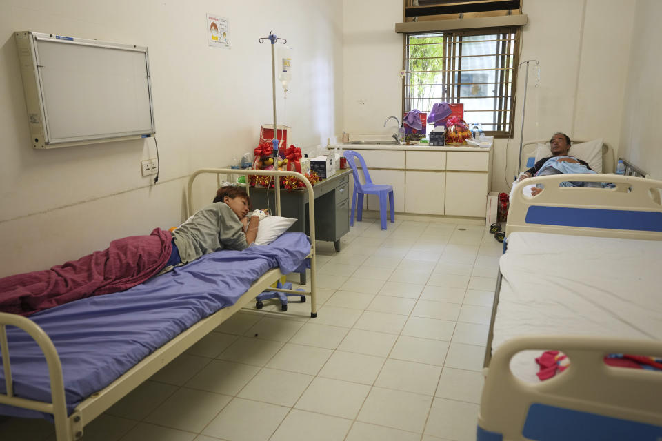 Survivors Huang Qian, 20, left, and Zhu Pingfan, 41, both from Hunan province in China, recuperate in hospital beds, Saturday, Sept. 24, 2022, Preah Sihanouk Province, Southwestern Cambodia after being rescued from a sinking boat days earlier. Authorities are searching for multiple people in the surrounding waters after their boat sank near Cambodia's Koh Tang island on Thursday. (AP Photo/Heng Sinith)