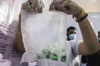 A health worker shows vials of COVISHIELD vaccine at the Guwahati Medical College hospital in Gauhati, India, Monday, March 1, 2021. India is expanding its COVID-19 vaccination drive beyond health care and front-line workers, offering the shots to older people and those with medical conditions that put them at risk. (AP Photo/Anupam Nath)