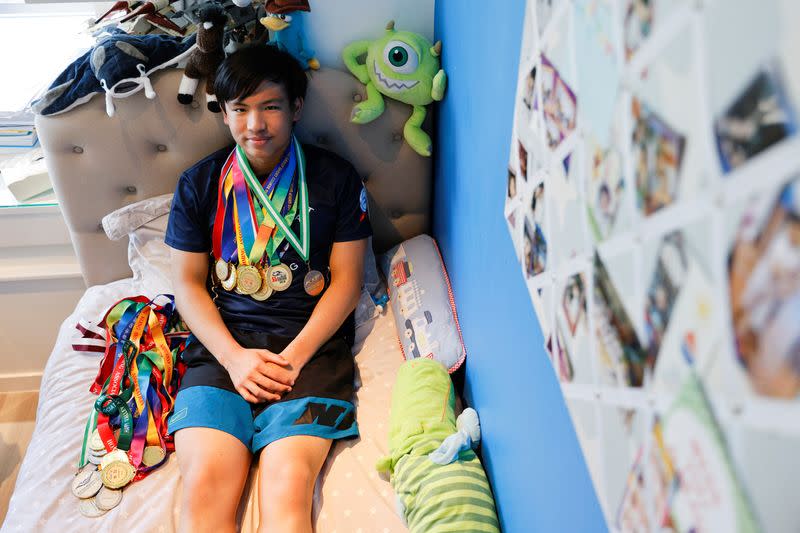 Competitive swimmer Jody Lee, 15, poses with his medals, in Hong Kong