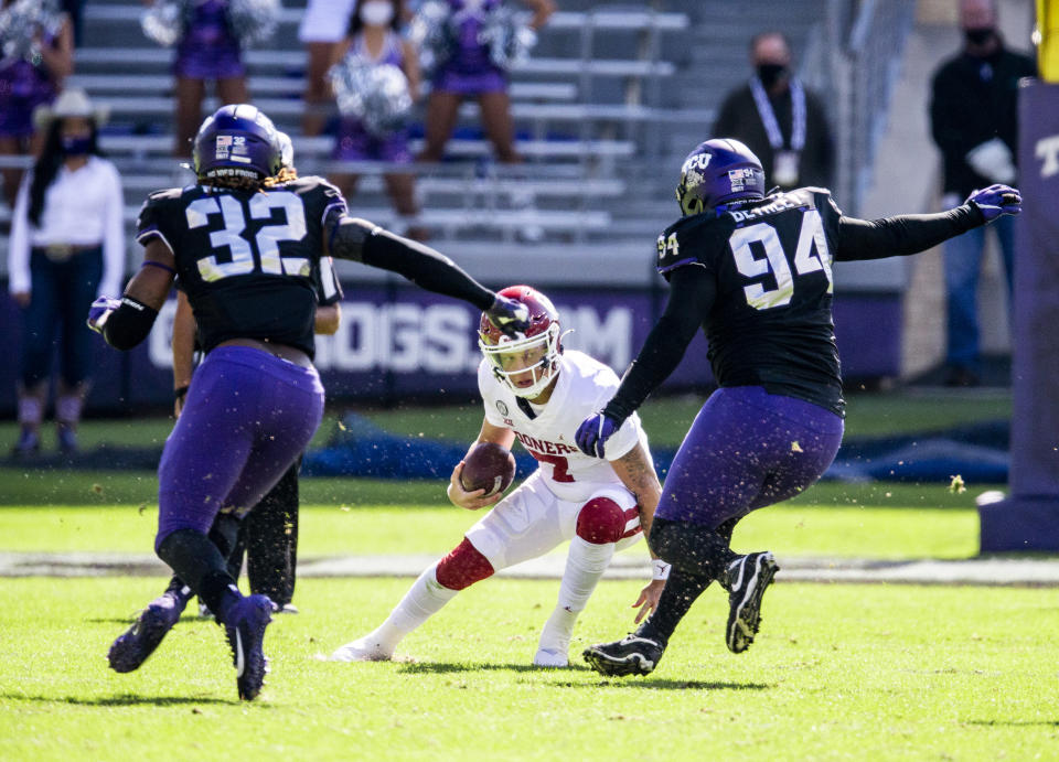 Oklahoma Sooners quarterback Spencer Rattler (7) looks for room against TCU defensive end Ochaun Mathis (32) and defensive tackle Corey Bethley (94) during the first half of an NCAA College football game, Saturday, Oct. 24, 2020, in Fort Worth, Texas. (AP Photo/Brandon Wade)