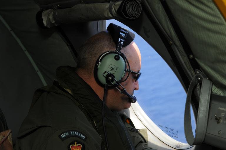 A crew member on a Royal New Zealand Airforce P-3K2-Orion aircraft searches for Flight MH370 off Perth on April 13, 2014