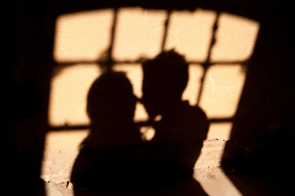 A picture of the shadows of a couple kissing.