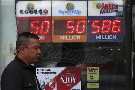 A man walks past a Mega Millions lottery sign with the estimated jackpot of $586 million posted in Alhambra, California December 16, 2013. REUTERS/Jonathan Alcorn