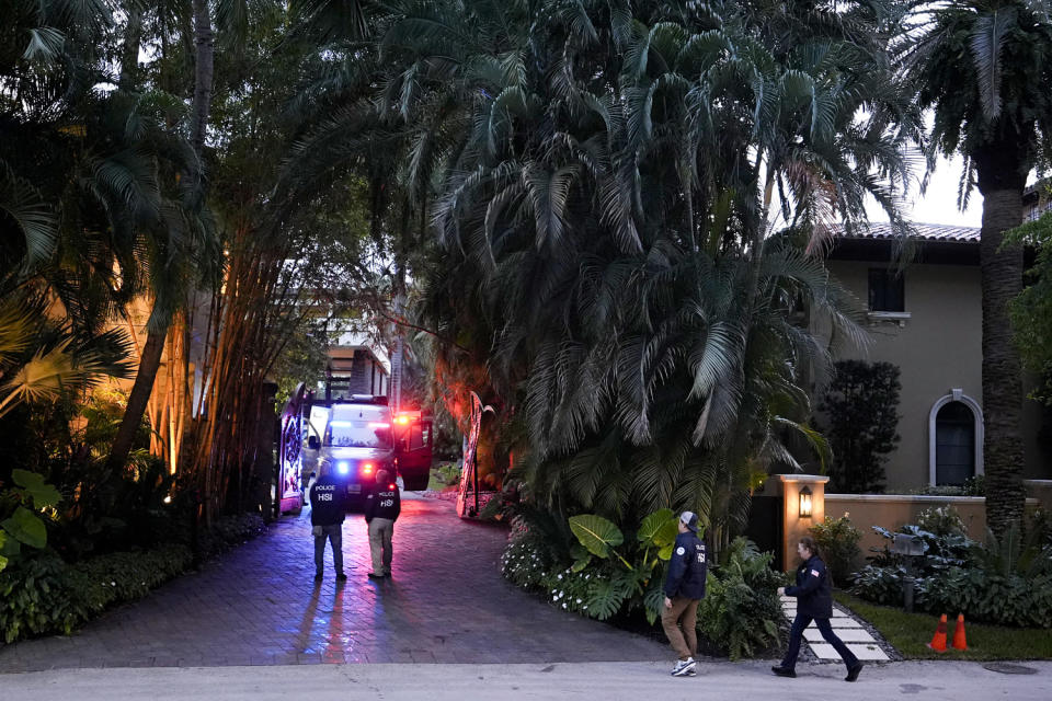 Federal agents walk at the entrance to a property belonging to Sean 