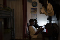 Adam Schneider, 7, center right, reads on a tablet computer with his older brother Isaiah, 9, in their bedroom, Wednesday, Dec. 8, 2021, in the Brooklyn borough of New York. Their mother April Schneider says she is lucky her two oldest children attend the same school and can share technology. "When one computer is down, we can us the other," said Schneider. "There needs to be more computers. More staff. More outreach." (AP Photo/John Minchillo)