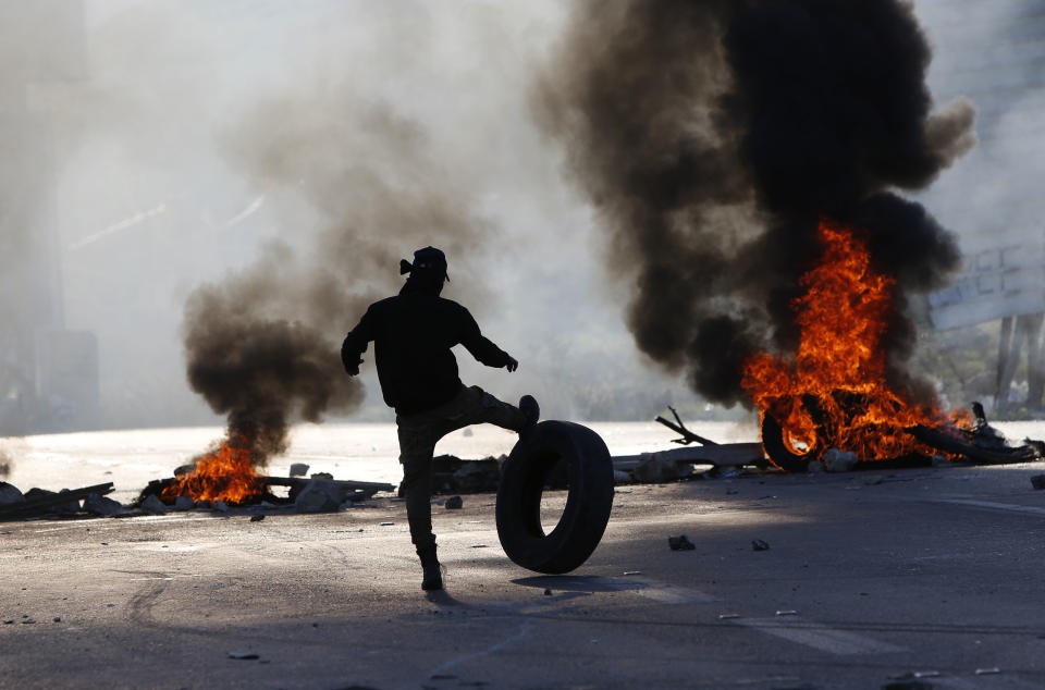 Palestinian protesters set tires on fire during clashes with Israeli troops at the Hawara checkpoint, south of the West Bank city of Nablus, Friday, Dec. 14, 2018. (AP Photo/Majdi Mohammed)