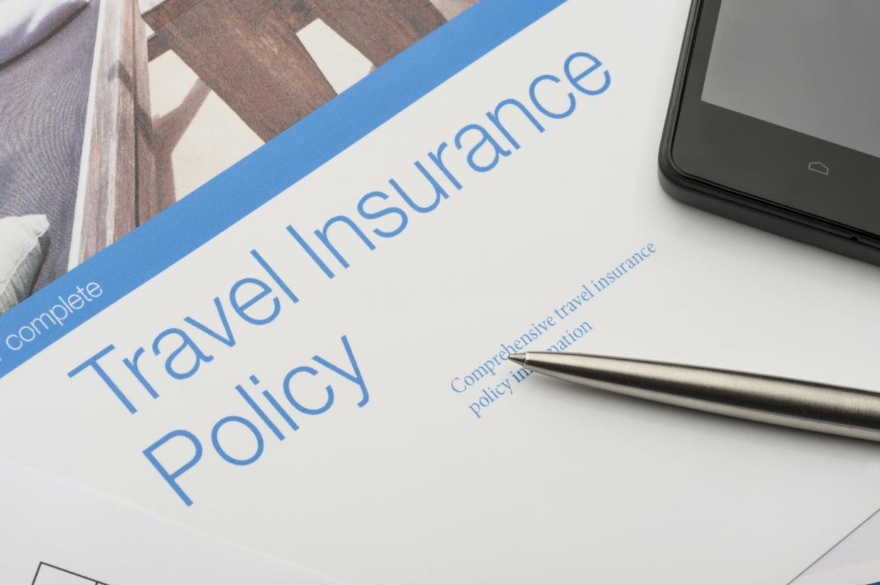 Travel insurance policy document with paperwork and technology. Peace of mind concept. There is also a mobile phone and pen. Close-up. Image featured on the brochure is in my portfolio file no:. 20943516