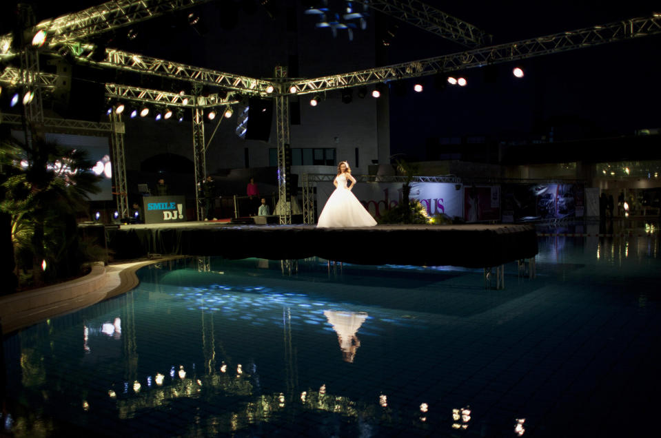 In this photo taken Friday, May 2, 2014, a model displays a creation by designer Fayzeh Pearl during the second day of the Palestine Fashion Week in the West Bank city of Ramallah. Pearl showed off more traditional designs, including beaded wedding dresses and colorful formal attire. (AP Photo/Nasser Nasser)