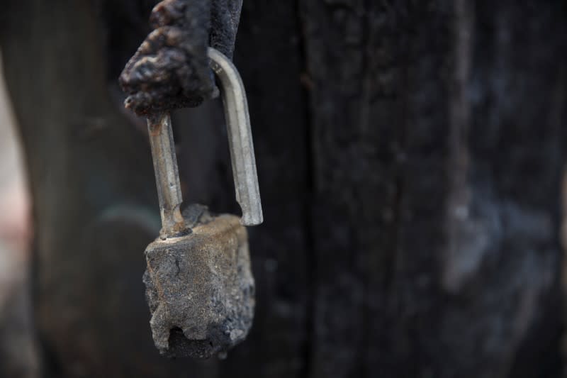 A burned lock is seen at the gate of a property damaged by bushfires in Kangaroo Valley, Australia