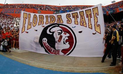 Nov 30, 2013; Gainesville, FL, USA; Florida State flag is held up before the team runs through it against the Florida Gators at Ben Hill Griffin Stadium. (Kim Klement-USA TODAY Sports)