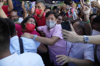 Presidential candidate Ferdinand "Bongbong" Marcos Jr. greets the crowd as he celebrates outside his headquarters in Mandaluyong, Philippines on Wednesday, May 11, 2022. Marcos' apparent landslide victory in the Philippine presidential election is raising immediate concerns about a further erosion of democracy in Asia and could complicate American efforts to blunt growing Chinese influence and power in the Pacific. (AP Photo/Aaron Favila)