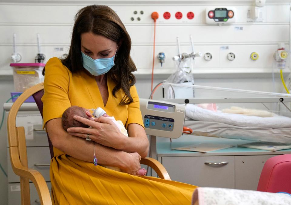 Britain&#39;s Catherine, Princess of Wales, wearing a face mask to help mitigate the possible spread of Covid-19, speaks to mew mother Sylvia Novak (unseen), whilst holding Sylvia&#39;s new-born daughter Bianca, during a visit to the Royal Surrey County Hospital&#39;s maternity unit in Guildford, south west of London on October 5, 2022. (Photo by Alastair Grant / POOL / AFP) (Photo by ALASTAIR GRANT/POOL/AFP via Getty Images)