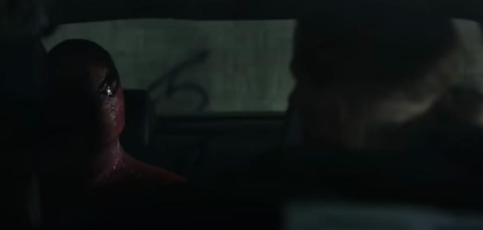 Spider-Man talking to a car thief inside a car in "The Amazing Spider-Man"