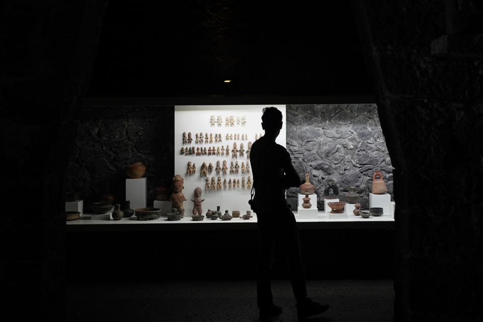 A visitor looks at pre-Hispanic ceramics on display at the Anahuacalli Museum in Mexico City, Tuesday, Aug. 20, 2024. Built by Mexican artist Diego Rivera to preserve and display his lifelong collection of pre-Hispanic art, the museum is celebrating its 60th anniversary. (AP Photo/Eduardo Verdugo)