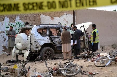 Security officers collect evidence as they investigate crime scene after a bomb exploded next to a convoy of deputy chairman of the Pakistan Senate, Senator Ghafoor Haideri in Mastung, Pakistan, May 12, 2017. REUTERS/Naseer Ahmed