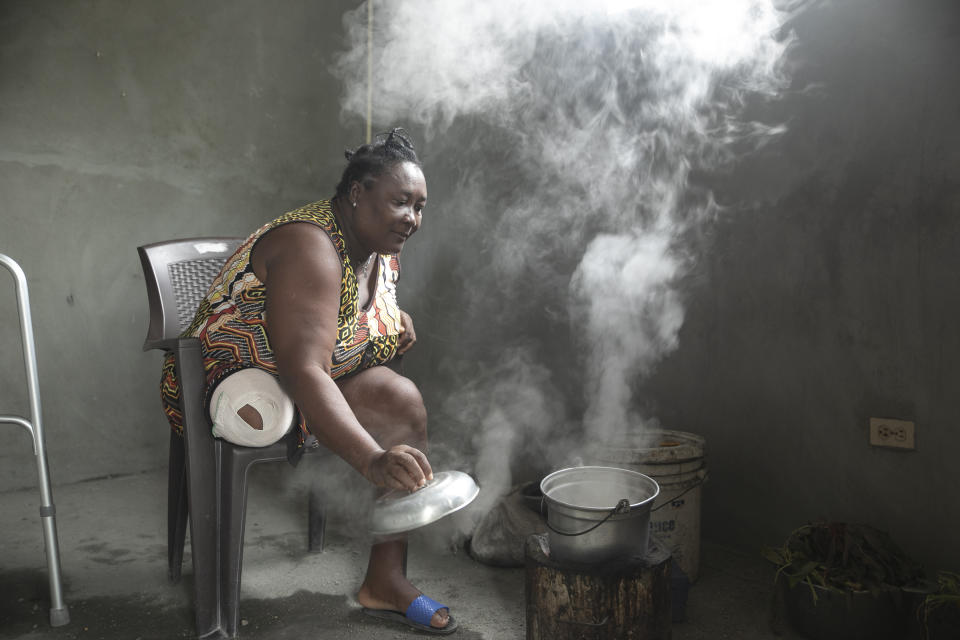 Duverseau Marie Cephta, whose leg was amputated when she was injured by last year's 7.2-magnitude earthquake, cooks in her home in the Lagodray area of Les Cayes, Haiti, Friday, Aug. 19, 2022. (AP Photo/Odelyn Joseph)