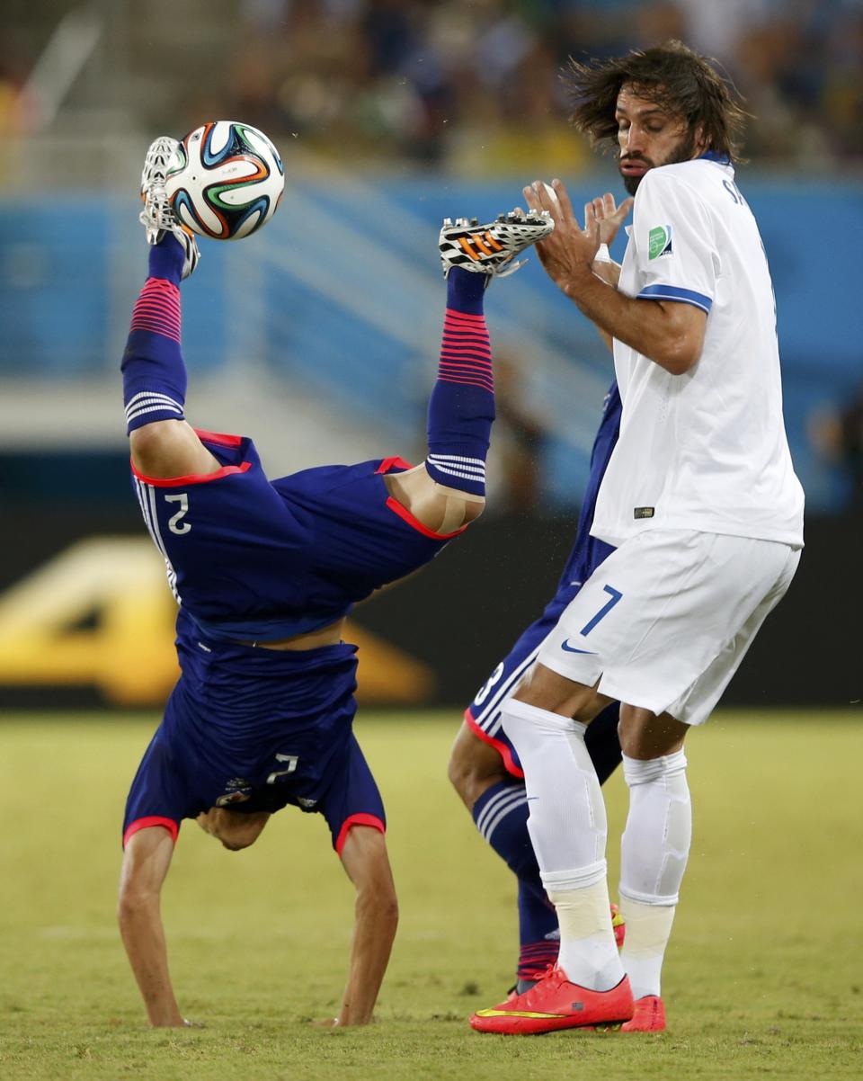 Greece's Giorgios Samaras commits a foul against Japan's Atsuto Uchida (L) during their 2014 World Cup Group C soccer match at the Dunas arena in Natal June 19, 2014. REUTERS/Toru Hanai