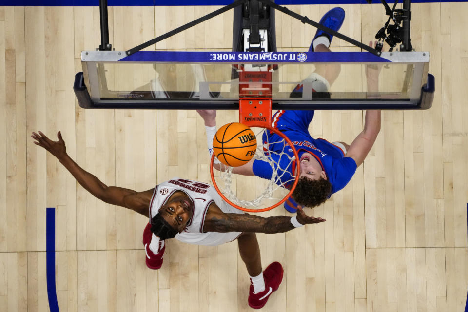 Florida center Micah Handlogten (3) scores as Alabama forward Nick Pringle (23) defends during the second half of an NCAA college basketball game at the Southeastern Conference tournament Friday, March 15, 2024, in Nashville, Tenn. (AP Photo/John Bazemore)