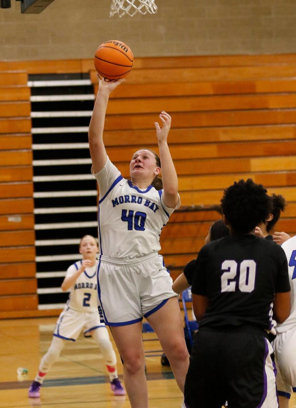 Morro Bay High School girls basketball team beats Rancho Cucamunga 49 - 29 in the CIF state playoffs at Morro Bay High School, Tuesday, Feb. 27, 2024. Tailer Morrison makes one of the many baskets in this game. Rancho Cucamunga Zara Ahaiwe (20) watches.