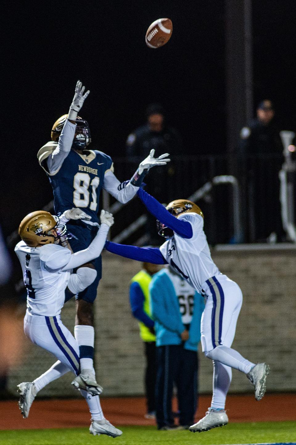 Newburgh's Deondre Johnson leaps up to catch the ball through CBA defenders during the NYSPHSAA Class AA semifinal football game in Middletown on Saturday, November 26, 2022. Newburgh defeated Christian Brothers Academy.