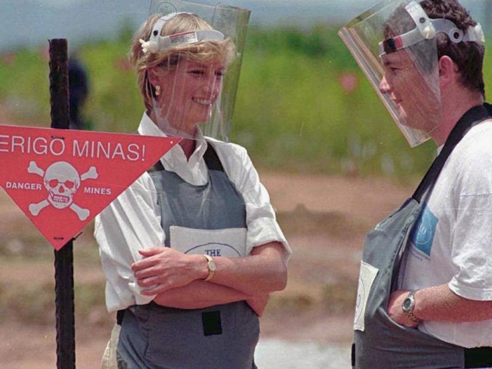 Diana wearing a heavy duty protection vest and face shield, accompanied by a mine-clearing expert of the Halo Trust 15 January 1997 during her visit to the mine fields near Huambo, Angola (AFP/Getty Images)