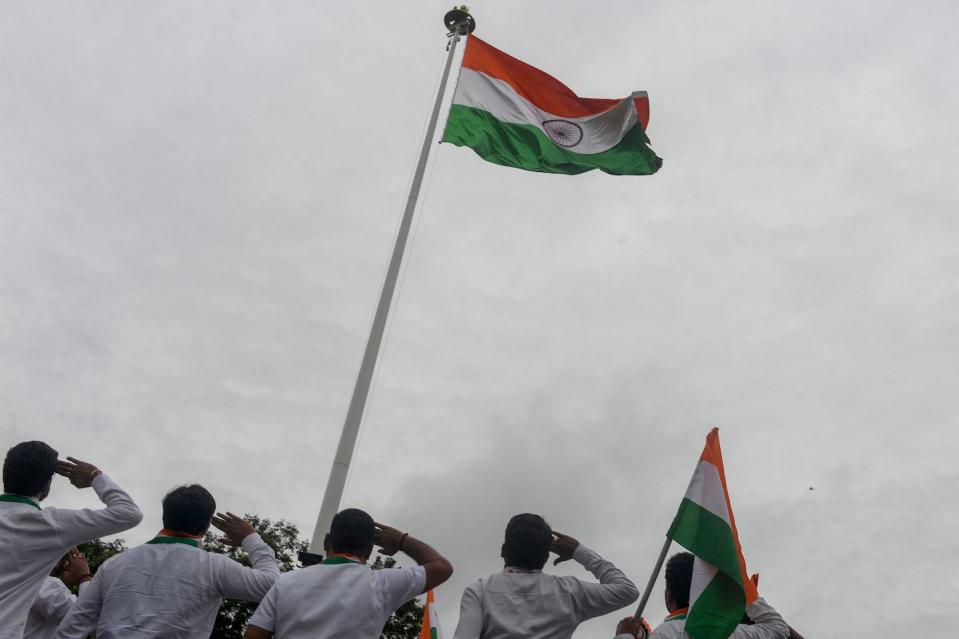 Saluting the Indian flag in Hyderabad before a rally to mark the 75th anniversary of the country’s independence on Aug. 8, 2022. <a href="https://www.gettyimages.com/detail/news-photo/employees-of-department-of-posts-india-salute-to-the-indian-news-photo/1242378413?adppopup=true" rel="nofollow noopener" target="_blank" data-ylk="slk:Noah Seelam/AFP via Getty Images;elm:context_link;itc:0;sec:content-canvas" class="link ">Noah Seelam/AFP via Getty Images</a>