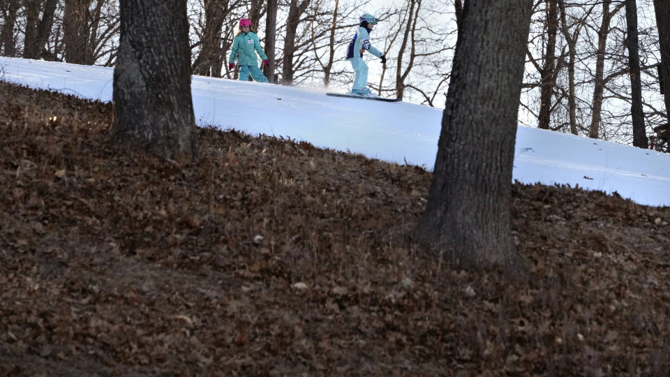 Skiers ride on a trail, made of completely machine-made snow, at the Ski Bradford ski area, Tuesday, Feb. 14, 2023, in in Bradford, Mass. Snow totals are far below average from Boston to Philadelphia in 2023 and warmer temperatures have often resulted in more spring-like days than blizzard-like conditions. (AP Photo/Charles Krupa)