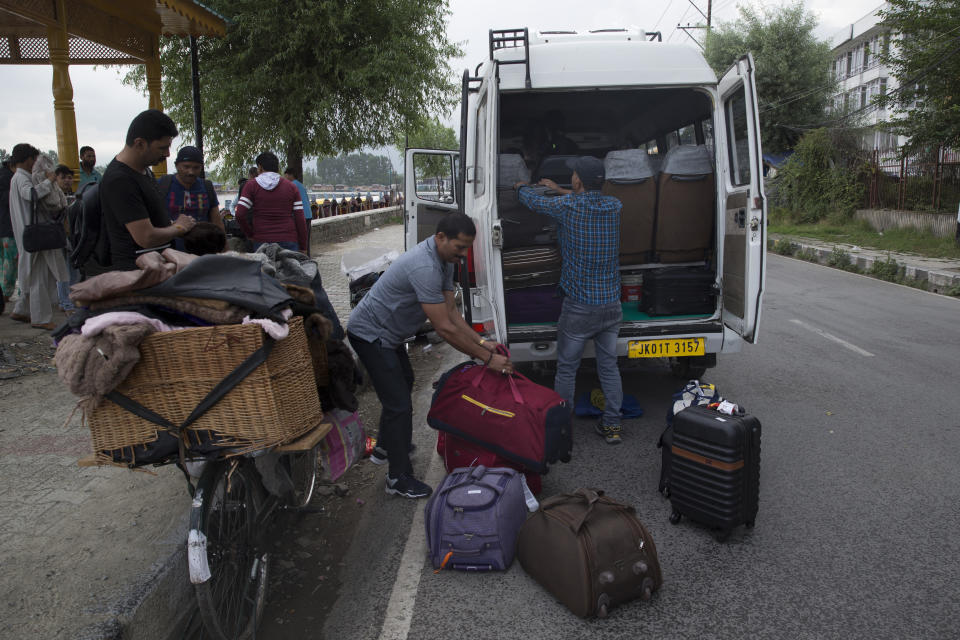 Indian tourists load their luggage as they prepare to leave Srinagar, Indian controlled Kashmir, Saturday, Aug. 3, 2019. A government order in Indian-administered Kashmir on Friday asked tourists and Hindu pilgrims visiting a Himalayan cave shrine "to curtail their stay" in the disputed territory, citing security concerns and intensifying tensions following India's announcement it was sending more troops to the region. (AP Photo/ Dar Yasin)