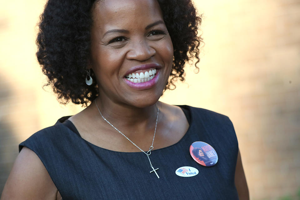 Acting Mayor Kim Janey smiles while wearing a campain pin next to an 