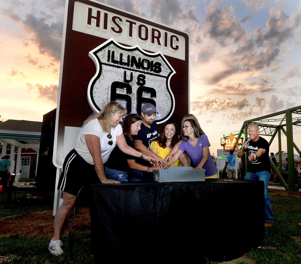 Springfield Mayor Misty Buscher, center right, and the organizing representatives of the Route 66 Experience flip the switch to turn on the lights of the attraction at the Illinois State Fair Grounds Wednesday, July 26, 2023.