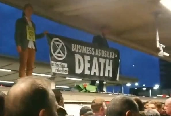 The protesters were seen holding a banner reading "Business as usual = death". (PA)